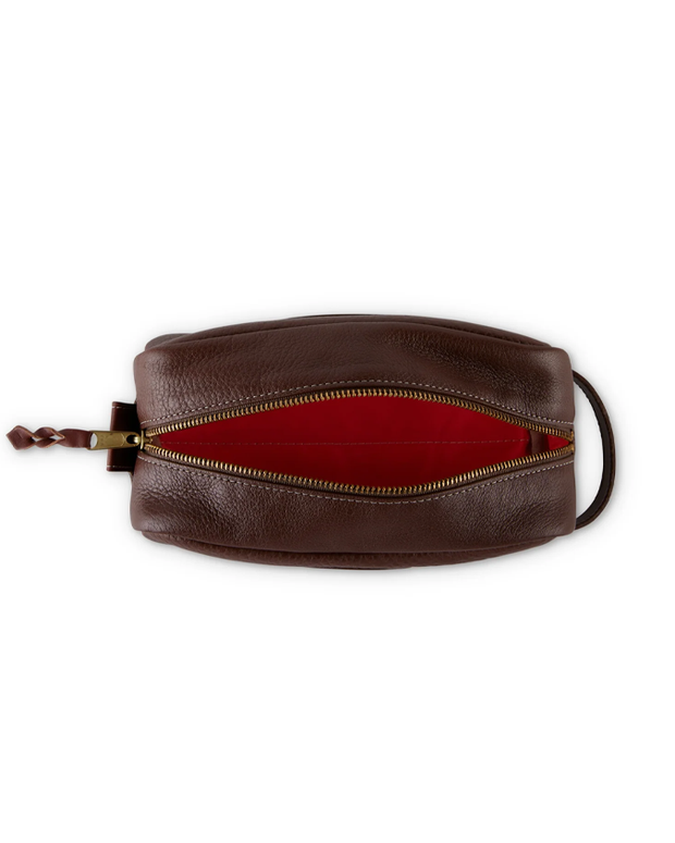 A top view of a brown leather pouch with a golden zipper, showcasing a luxurious red interior, ideal for carrying small personal items.