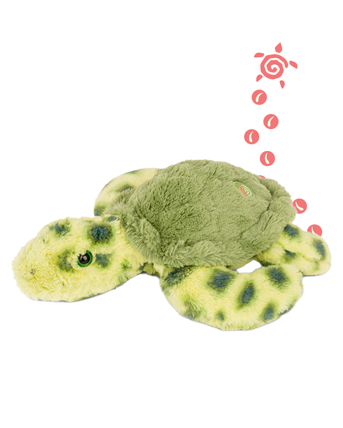 A green turtle plush toy with dark green spots on the body and green eyes laying against a plain background. There is also an illustration of a small pink turtle with circles trailing behind it on the right side of the image.