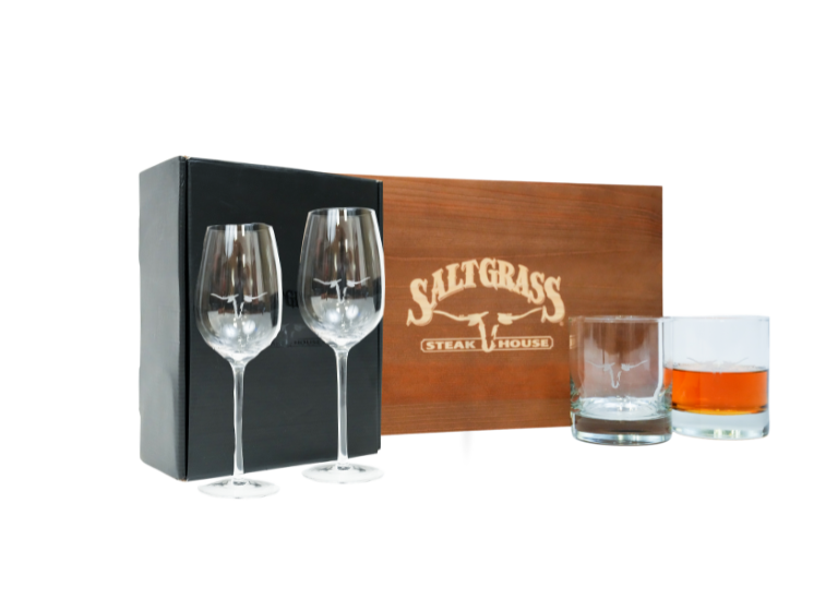A gift set featuring Saltgrass Steakhouse branded wine glasses, a rocks glass, and a stylish wooden box.