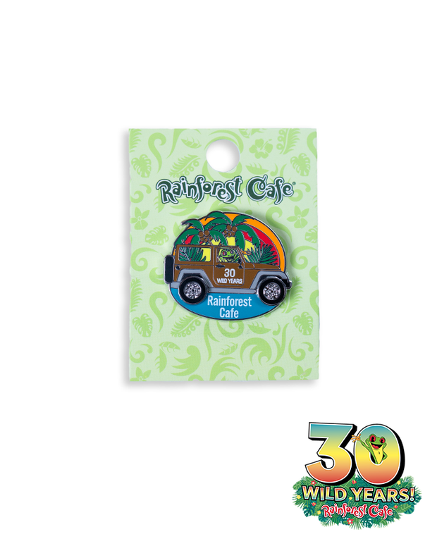 A collectible pin from Rainforest Cafe, featuring a colorful car adorned with tropical designs to commemorate the cafe’s 30th anniversary. The pin is shaped like a car, decorated with vibrant colors and palm leaves, marked with ‘30 WILD YEARS’ on the car itself. It’s attached to a light green card with the Rainforest Cafe logo at the top and bottom with a frog sticking out the 0.