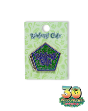 A collectible pin from Rainforest Cafe, celebrating ‘30 Wild Years!’ The pin is pentagon-shaped with a blue background and intricate green designs. The center features the Rainforest Cafe logo in bold letters. It’s attached to a light green card with darker green rainforest-themed patterns and the logos ‘Rainforest Cafe’ and ‘30 WILD YEARS! Rainforest Cafe’ with a tree frog sticking out the 0