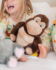 Little girl hugging Bamba the Gorilla plush while wearing Jungle Party PJ set.