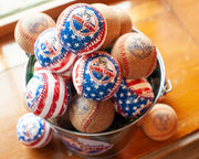 Cork baseballs with Blue Bubba Gump Logo, and American Flag print baseballs with Bubba Gump logo in a tin.