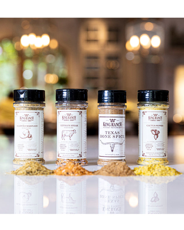 King Ranch seasonings in a line with pile of each seasoning in front of the bottle.