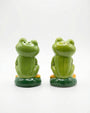 Two green frog-shaped salt and pepper shakers on a white background