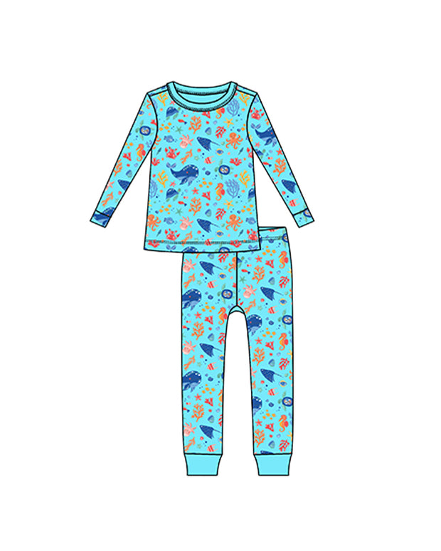 A colorful children’s pajama set with a blue background and a pattern of various sea animals-themed elements like octopus, sea horse, fish, whale and coral. 