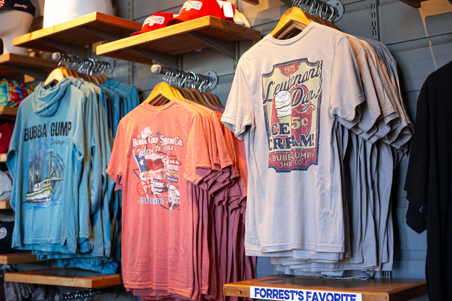 Bubba Gump tee shirts in the store wall on hangers. 