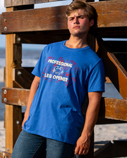 male model leaning against lifeguard post wearing Retro Heather Royal tee with red crab silhouettes on right and left side. In center reads "professional leg opener" in cream color with a crab silhouette in between.