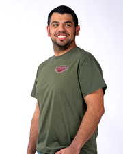 A person wearing green t-shirt with a small red and white logo on the left chest area reading 'BUBBA GUMP SHRIMP CO.'