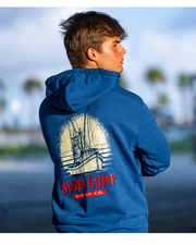back view of male model wearing Back of royal blue bubba gump hoodie with back white and red graphics. Graphic features a boat and large exaggerated sun behind the ship with a splattered design. Below the ship graphics are the words "bubba gump shrimp co." 