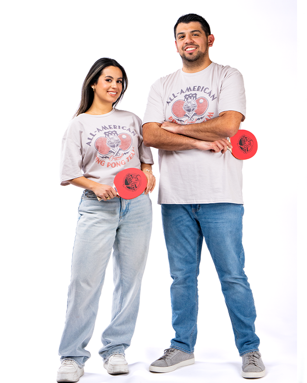 female model and male model wearing tees, denim pants and sneakers. both are also holding ping pong paddles in their hand.