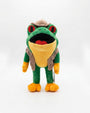 A green and yellow frog plush toy wearing a tan hat and backpack, standing against a plain white background.
