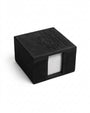 A black square napkin holder with a textured faux-leather finish, featuring the embossed text 'IT'S FREE TO BE NICE' on the lid and a clear window on the front showing white paper napkins inside.