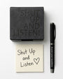 A black leather wallet with 'SHUT UP AND LISTEN!' embossed on the front, shown next to a cream sticky note that says 'Shut Up and Listen' and a black pen with 'Know your numbers.' printed on it, all arranged on a white background.