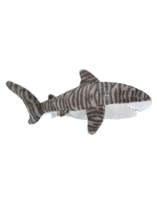A plush toy shaped like a tiger shark, set against a white background. It showcases a realistic color pattern with dark grey stripes on a lighter grey body, mimicking a tiger shark’s distinctive markings. The toy has a white underbelly and mouth area with small, friendly-looking teeth, along with fins and a tail that reflect the true anatomy of a tiger shark, adding to its lifelike yet approachable appearance.