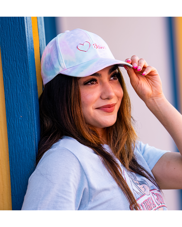 girl wearing Pastel tie dye cap with a heart and "Bubba" embroidered in white with red outline.