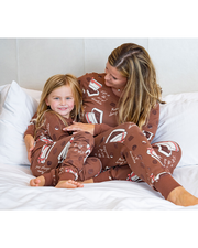 mom and daughter on bed wearing matching brown pajamas that have box of chocolate icons.