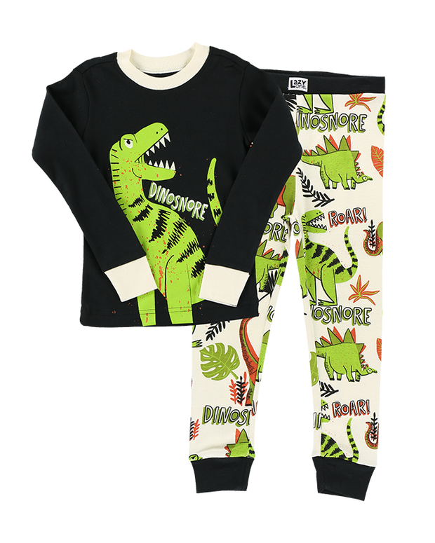 A children’s pajama set with a black top featuring a large green dinosaur print and the word ‘DINOSNORE’, paired with white bottoms that have smaller dinosaur prints and the exclamations ‘ROAR!’ and ‘DINOSNORE’, all laid out against a white background.