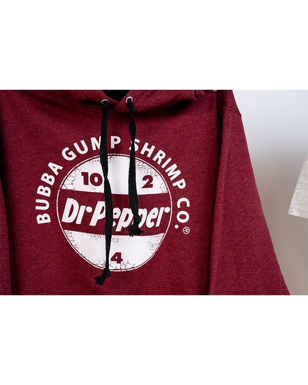 close up of Burgundy hoodie with black drawstrings. In center chest, reads "bubba gump shrimp co." curved over the Dr Pepper circular logo.