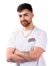 A person in a white t-shirt featuring the ‘JOE’S CRAB SHACK’ logo, adorned with a gold necklace, and arms crossed.