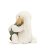 White plush toy resembling a penguin holding a green tree on a white background