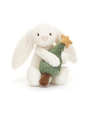 White plush bunny holding a small green tree with a gold star on a white background