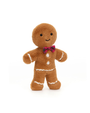 Stuffed gingerbread man toy with a plaid bow tie on a white background