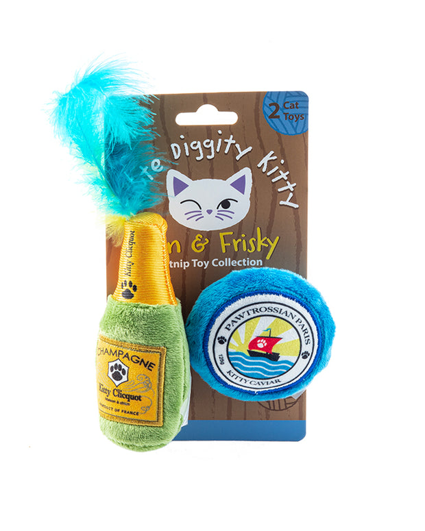 A product packaging for “Haute Diggity Kitty" featuring two cat toys. The left toy resembles a green champagne bottle with a label reading “Champagne” and a fluffy blue top, while the right toy is designed to look like a blue caviar tin with the label “Kityy Caviar.” Both toys are attached to a cardboard backing that has illustrations of cat ears and whiskers at the top, along with text indicating there are two cat toys included. 