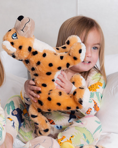 Little girl playing with Maya the Jaguar plush while wearing Jungle Party PJ set