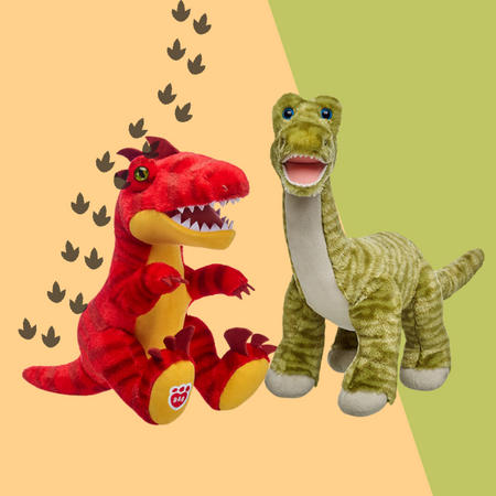 The image showcases two plush dinosaur toys against a split yellow and green background. On the left, a red dinosaur with yellow accents is in a roaring posture, while on the right, a green dinosaur with light green stripes appears cheerful. Above them, the text “NEW STYLES” is written in black, and the “BUILD-A-BEAR WORKSHOP” logo is displayed in the top right corner. The background also features small dark silhouettes of dinosaurs foot prints near the text.