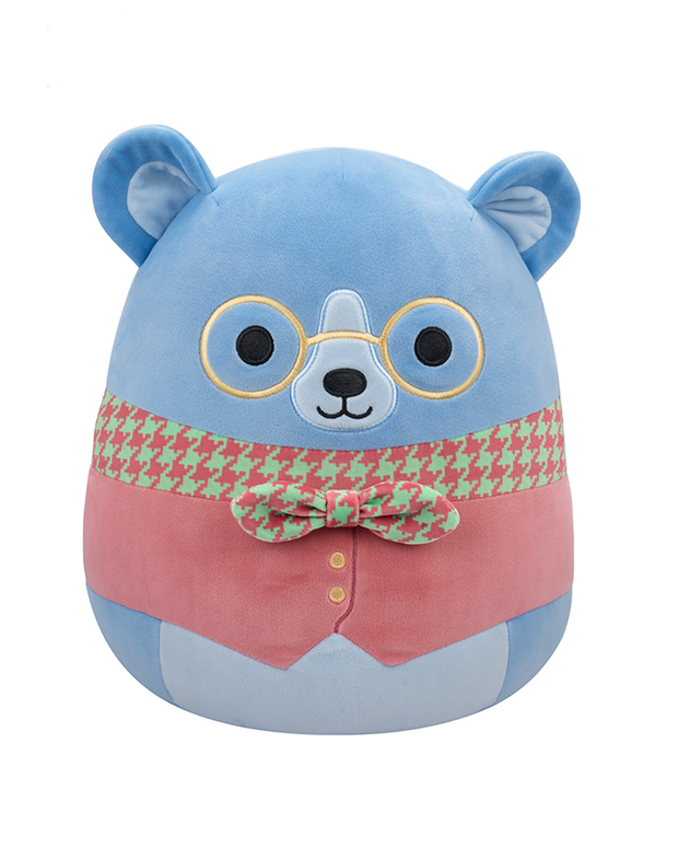 The image features a plush toy bear with a blue head, wearing gold-rimmed glasses, a green and red patterned vest, and a green bow tie. The bear’s blue head has two round ears, and the lower part of the toy is covered in soft pink fabric, giving the appearance of clothing or body fur contrasting with its blue head.