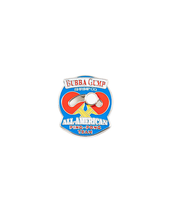 A blue pin with the text "BUBBA GUMP SHRIMP CO." at the top, "ALL-AMERICAN PING-PONG TEAM" at the bottom, and an illustration of two ping-pong paddles with a slidable ball in the center. The background is plain white.
