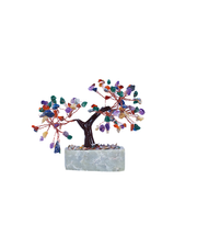 Multi color bonsai tree in soapstone pot in front of white background.