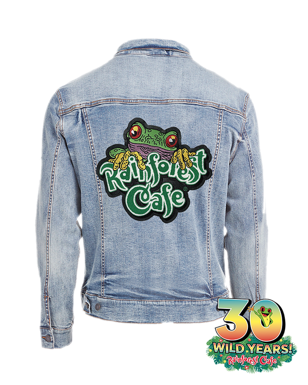 denim jacket with "rainforest cafe" patch on back that has a tree frog over the wording. Bottom right corner tag "30 wild years. rainforst cafe" with cha cha in center of the zero.