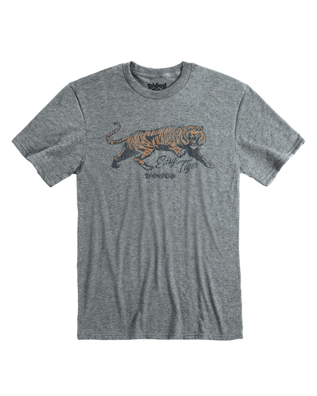 A casual grey t-shirt featuring a central printed design of a tiger in mid-stride with the phrase ‘Easy Tiger’ in cursive text above it. The shirt has a round, ribbed neckline and is made from a soft, comfortable fabric with a visible textile texture.