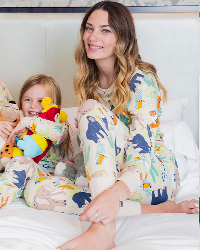 Mother cuddling her daughter in bed as both wear the Jungle Party PJ set.