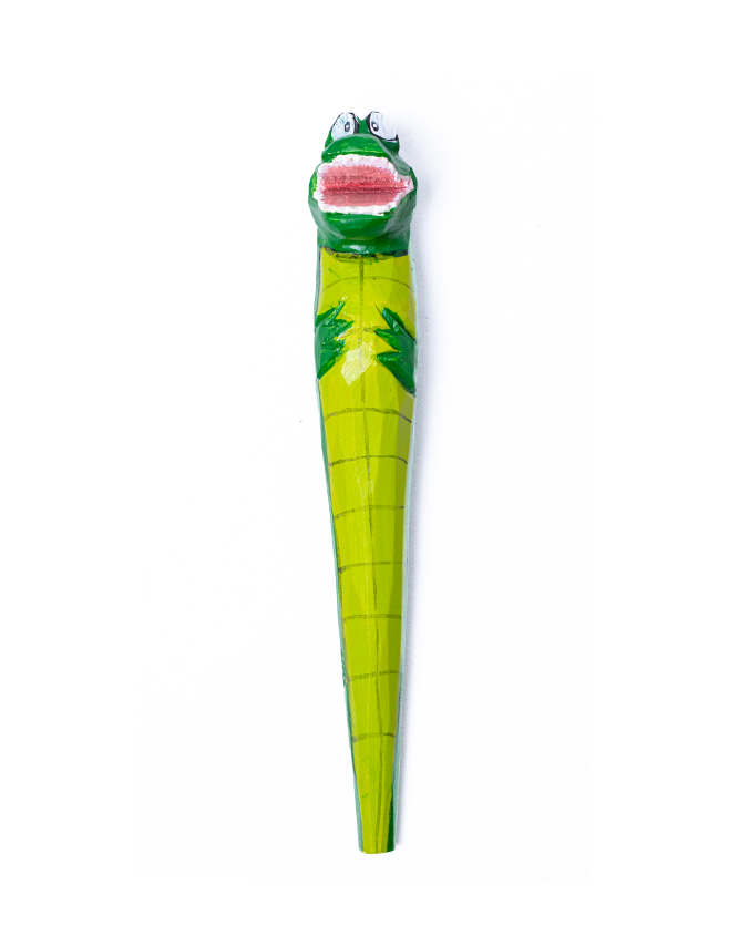 The pen features a crocodile head with big white eyes and black pupils, and a wide open mouth showing red inside. The body of the pen is adorned with dark green scales, adding to the crocodile-like appearance. The pen is set against a plain white background, emphasizing its colorful and whimsical design.