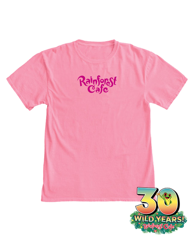A pink t-shirt with the embroidered text ‘Rainforest Cafe’ printed on the front, featuring a colorful logo at the bottom of the image celebrating ‘30 WILD YEARS!’ of Rainforest Cafe. The shirt has a round neckline and short sleeves.
