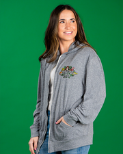 A person wearing a grey hoodie with a colorful ‘Rainforest Cafe’ logo on the left chest area, standing against a green background.