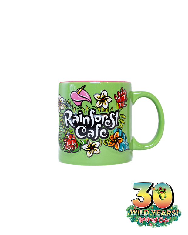 A vibrant green mug adorned with colorful, artistic illustrations of flowers and the logo ‘Rainforest Cafe,’ celebrating 30 wild years of the cafe. The mug features an emblem celebrating ‘30 WILD YEARS!’ of Rainforest Cafe with Cha Cha Sticking out the 0.