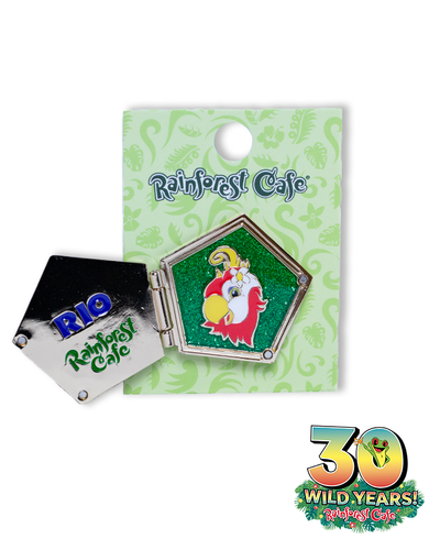 A collectible pin from Rainforest Cafe featuring a colorful parrot character, presented on a decorative card with the cafe’s logo and a special ‘30 Wild Years’ emblem. The pin is hexagonal with a green background, showcasing a red parrot with yellow wings and a white hat. The card is light green with darker green designs, and the ‘30 WILD YEARS!’ emblem at the bottom right corner with a tree fropg coming out the zero.