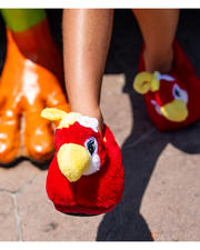 close up of little kid wearing Plush Rio the Parrot red and yellow slippers with a foam sole 