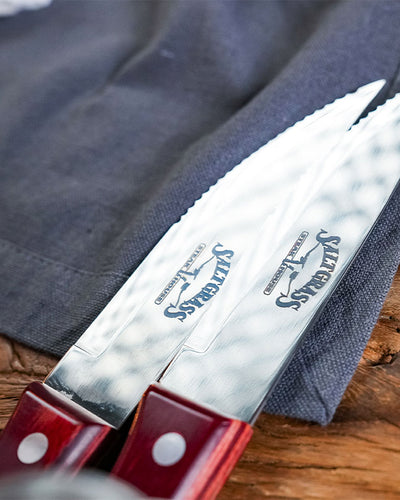 Close up of steak knives blades showcasing engravement of the saltgrass logo.