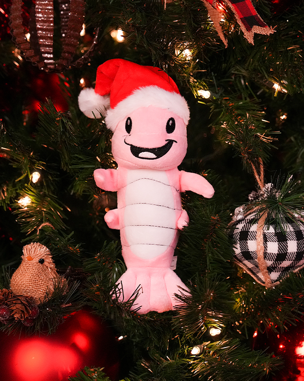close up of santa shrimp louie on a christmas tree surrounded by red ornaments.