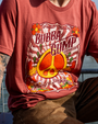 A close-up of a person wearing a rust-colored t-shirt featuring a vibrant "Bubba Gump Shrimp Co." design and peace symbol.