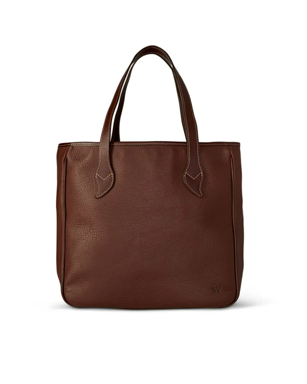 Brown leather tote bag in front of white background.