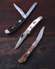 Image shows 3 styles of pocket knife on top a wooden table.