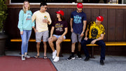 Group of 5 friends sitting on a bench with 3 of them wearing the limited edition Bubba Gump cap.