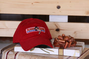 Limited edition red Bubba Gump cap placed on top of a box of chocolates that is sitting on a bench.
