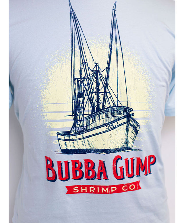 Close-up of the tee graphics. The boat is done in line drawings with dark blue outlines. The shrimp boat looks like a sketch drawing and has "Jenny" name on it. There is also Bubba Gump wording at the bottom of the boat graphic in red with a dark blue shadow cast. Below this is a red ribbon with the words: " shrimp co."